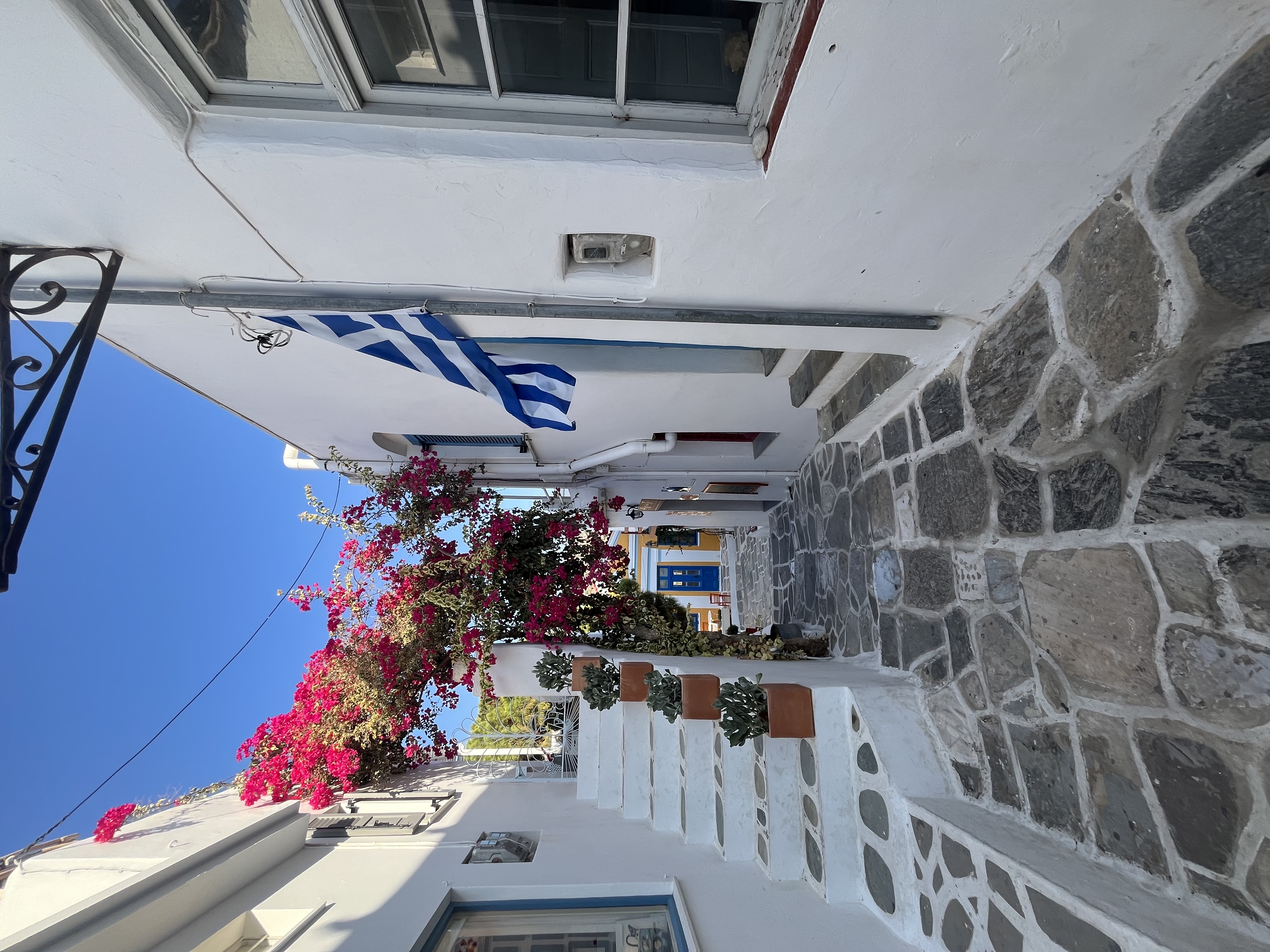 Classic Greek island alleyway with bougainvillea